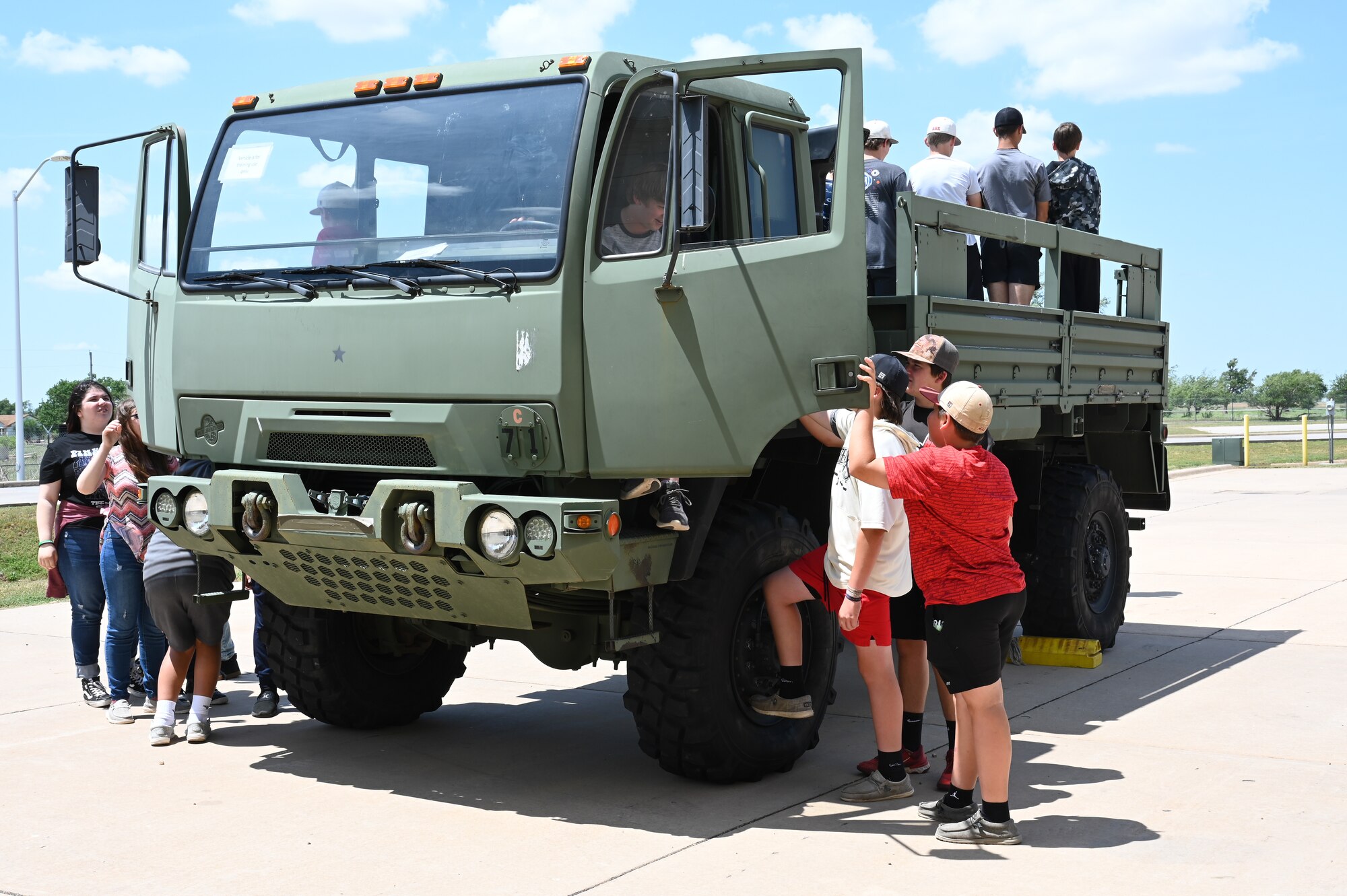 Students from Navajo Public Schools explore a light medium tactical vehicle at the 97th Logistics Readiness Squadron during the Aviation Inspiration and Mentorship (AIM) Wing tour at Altus Air Force Base, Oklahoma, May 10, 2023. The AIM tour provided hands-on learning opportunities highlighting different job functions available in the Air Force. (U.S. Air Force photo by Airman 1st Class Heidi Bucins)