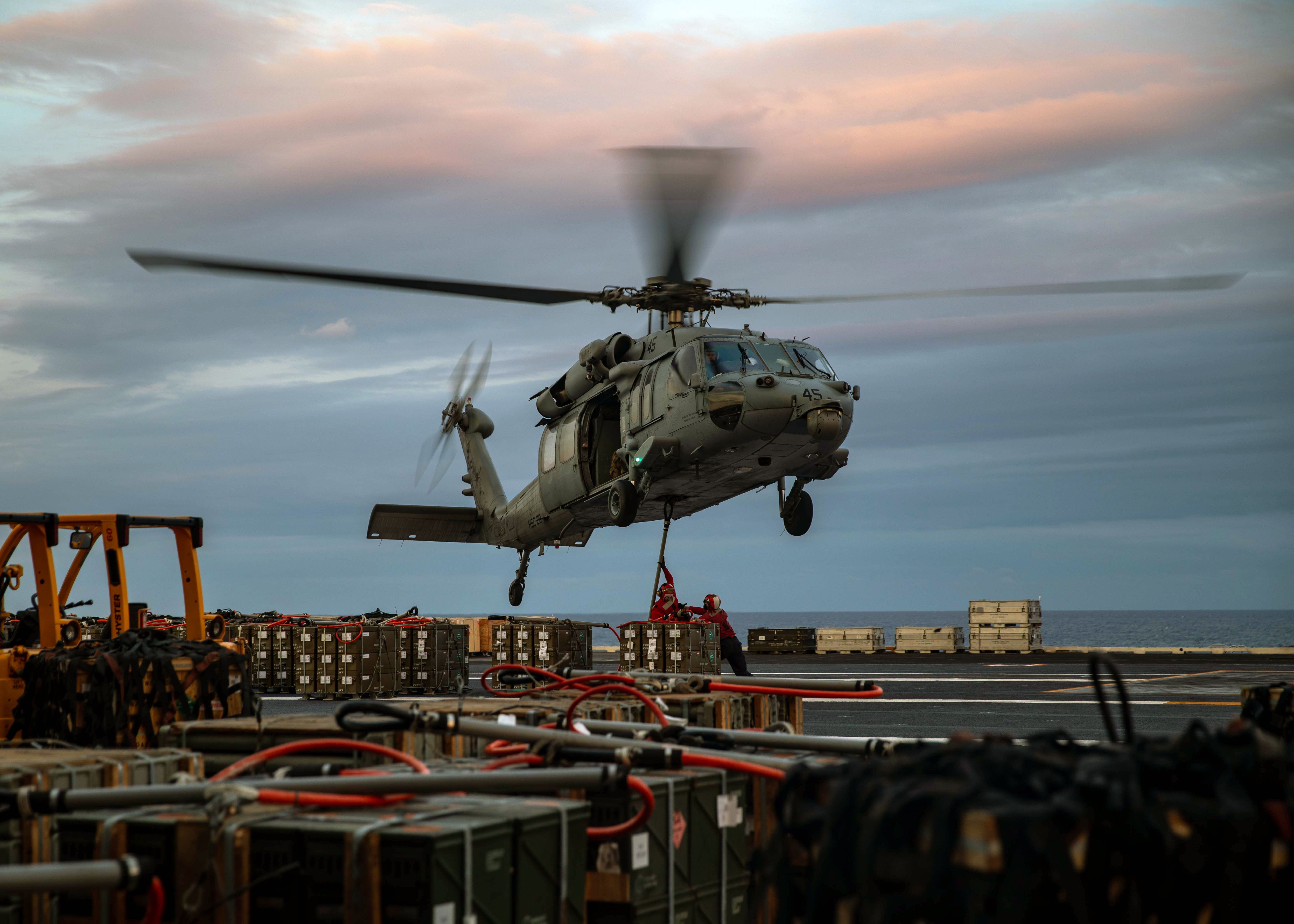 An MH-60S Sea Hawk helicopter, attached to Helicopter Sea Combat Squadron (HSC) 28, moves ordnance aboard the Nimitz-class aircraft carrier USS George H.W. Bush (CVN 77) during an ordnance transfer with the fast combat support ship USNS Supply (T-AOE 6).