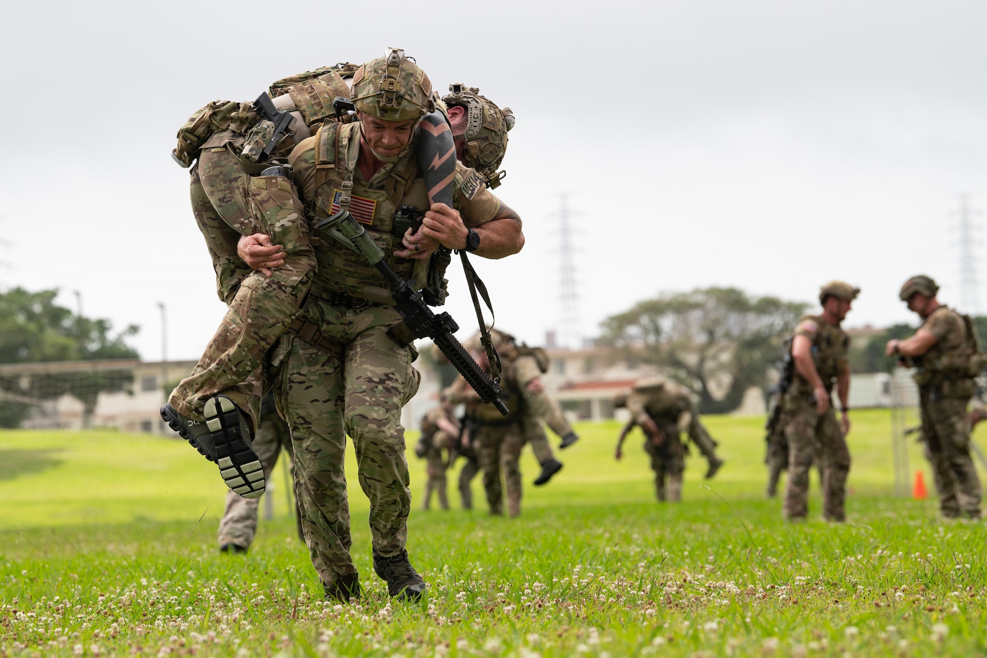 U.S. Air Force special tactics Airmen with the 320th Special Tactics Squadron conduct a buddy carry during Monster Mash, an operational readiness and resilience training, at Kadena Air Base, Japan, May 5, 2023. The Airmen were presented with multiple tasks throughout the seven mile route, including a humvee push, litter carries and fast rope insertions, all while wearing a full ensemble of body armor, weapons and equipment. (U.S. Air Force photo by Staff Sgt. Jessi Roth)
