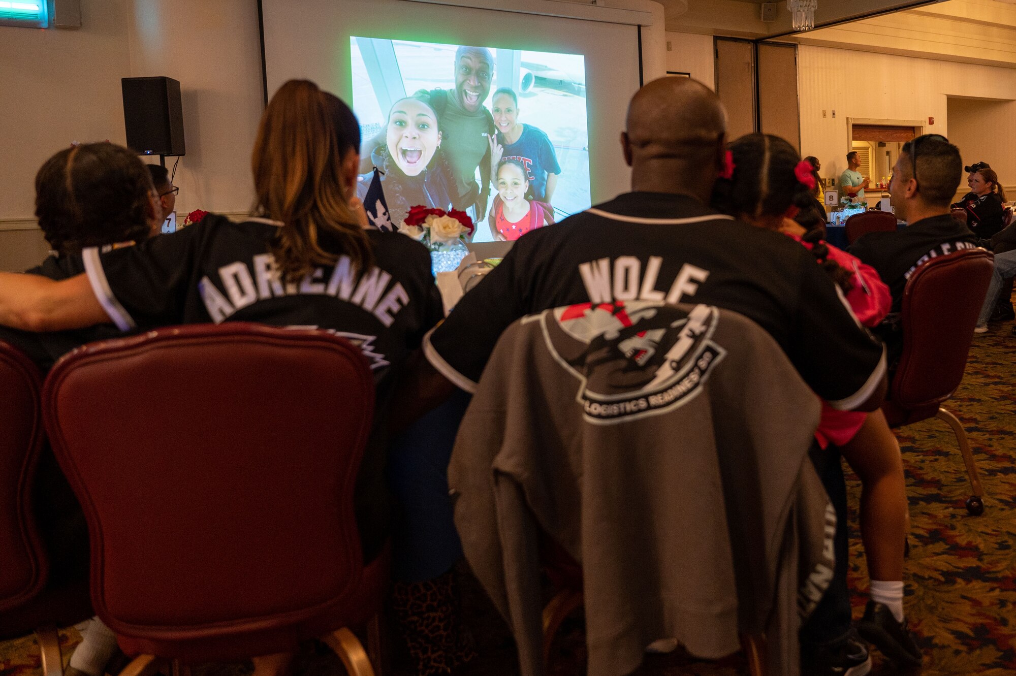 Col. Henry R. Jeffress, 8th Fighter Wing commander, and his family watch a video celebrating their time at Kunsan Air Base, Republic of Korea, during a going away ceremony, May 23, 2023. After three years on the Korean peninsula, the Jeffress family will return stateside for their next assignment. (U.S. Air Force photo by Tech. Sgt. Timothy Dischinat)