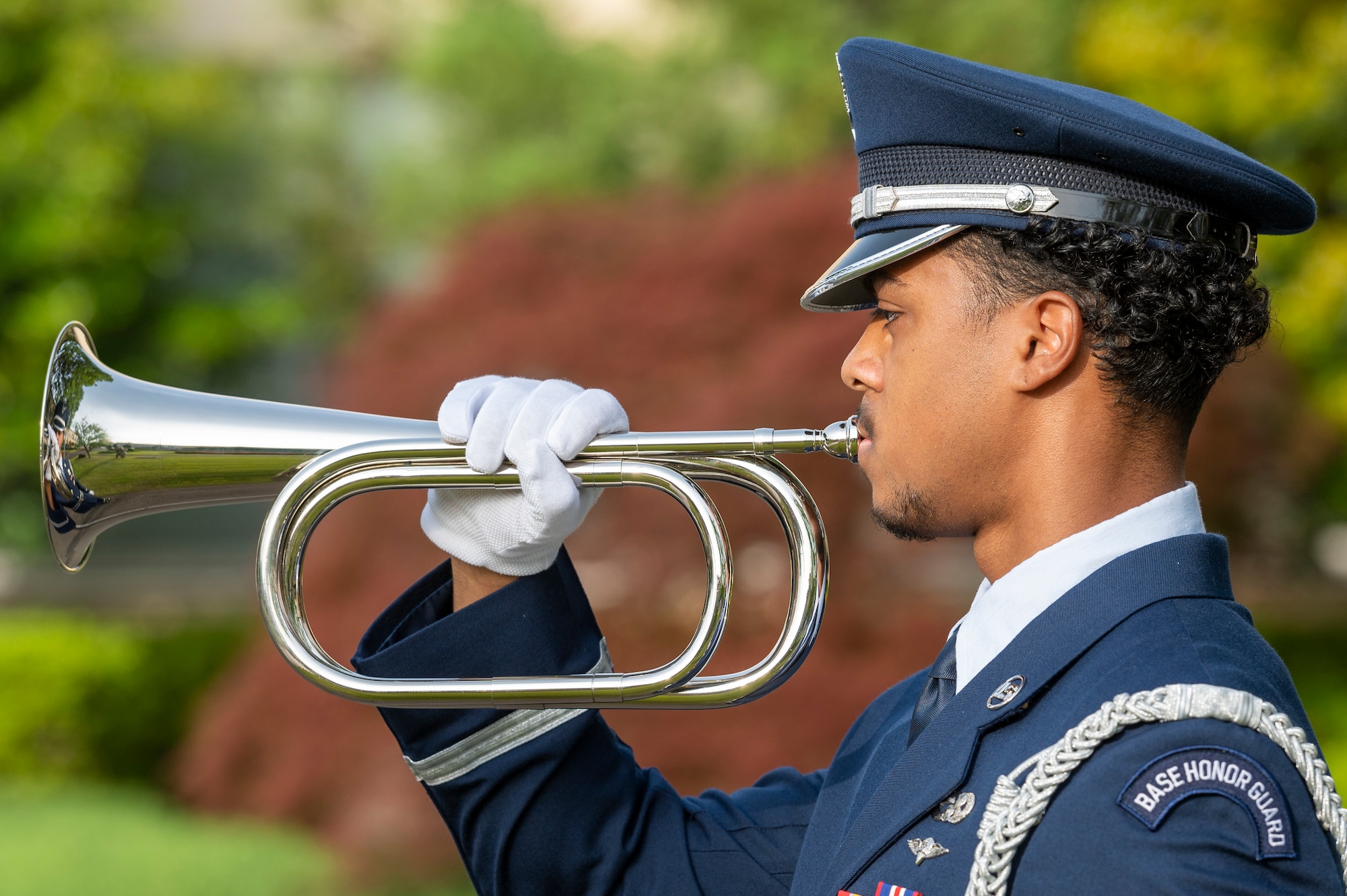 A formally dressed soldier playing a horn
