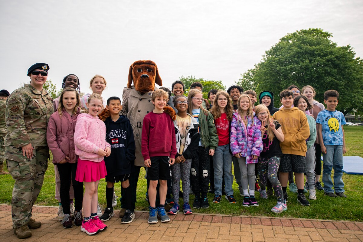 Students from Alconbury Elementary school pose for a photo with members from the 423d Security Forces Squadron at RAF Alconbury, England, May 18, 2023. As part of National Police Week students were able to engage with members and learn more about the capabilities of the 423d SFS. (U.S. Air Force photo by Staff Sgt. Eugene Oliver)