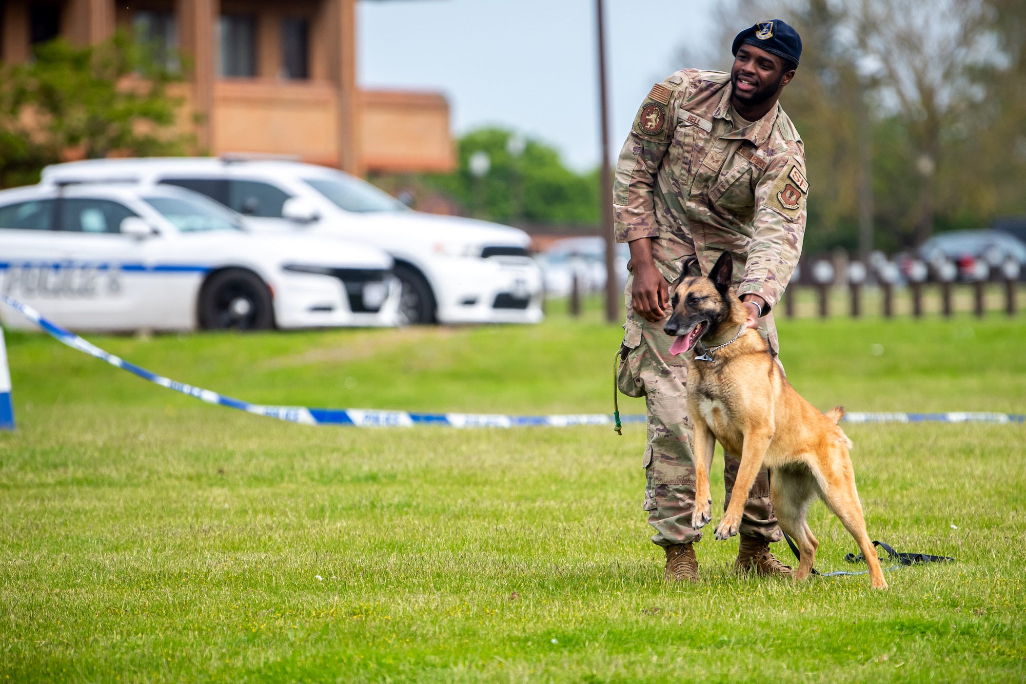U.S. Air Force Senior Airman Jelani Bell, 100th Security Forces Squadron Military Working Dog handler, holds MWD Uta, during a demonstration at RAF Alconbury, England, May 18, 2023. The demonstration was a part of National Police Week where members from SFS engaged with and demonstrated police capabilities to students from Alconbury Elementary school. (U.S. Air Force photo by Staff Sgt. Eugene Oliver)