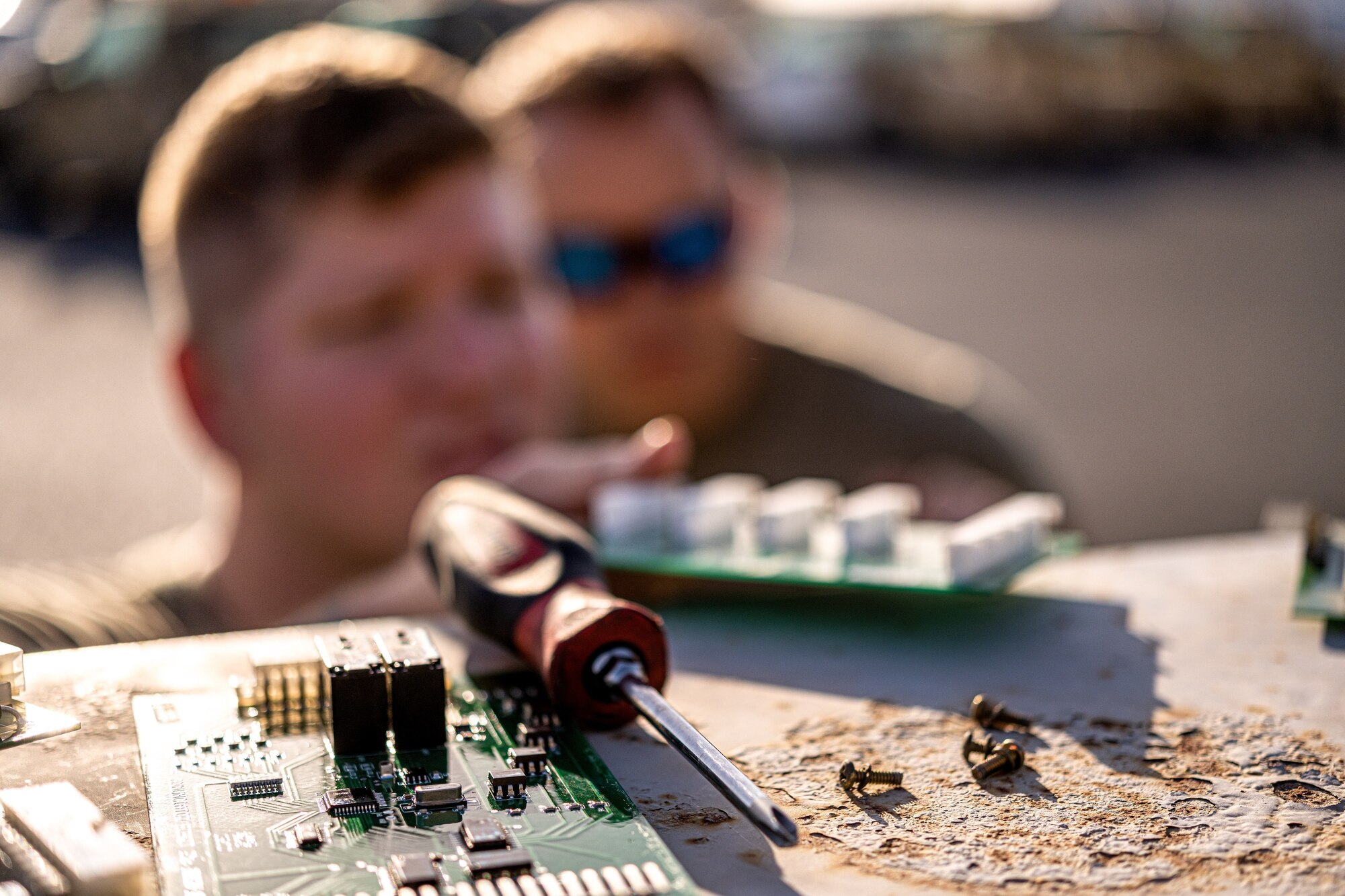 Photo of an Airman conducting maintenance on a large piece of equipment