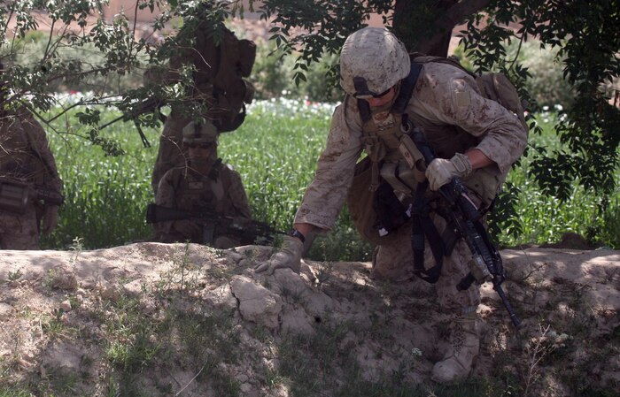 FORWARD OPERATING BASE INKERMAN, Helmand province, Islamic Republic of Afghanistan – Petty Officer 2nd Class Jonathan G. Booton, a corpsman from 4th Civil Affairs Group attached to 3rd Platoon, Company B, 1st Battalion, 5th Marine Regiment, climbs out of a wadi while on patrol through the green zone of Sangin April 17. Booton, who has been deployed since December 2010 with CAG, goes out with the platoon as a regular member of their patrols.