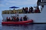 Haitians are transferred from Coast Guard Cutter Campbell's small boat to the cutter approximately 20 miles south of Turks and Caicos