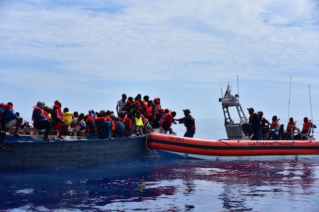 Haitians are transferred from a grossly overloaded, unsafe vessel to Coast Guard Cutter Campbell's small boat approximately 20 miles south of Turks and Caicos