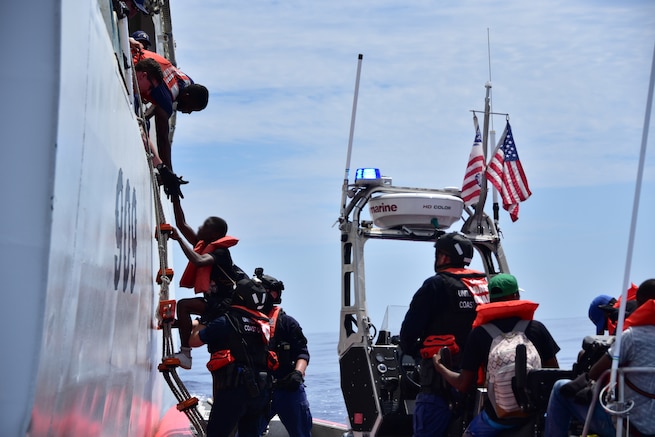 Haitians are transferred from Coast Guard Cutter Campbell's small boat to the cutter approximately 20 miles south of Turks and Caicos