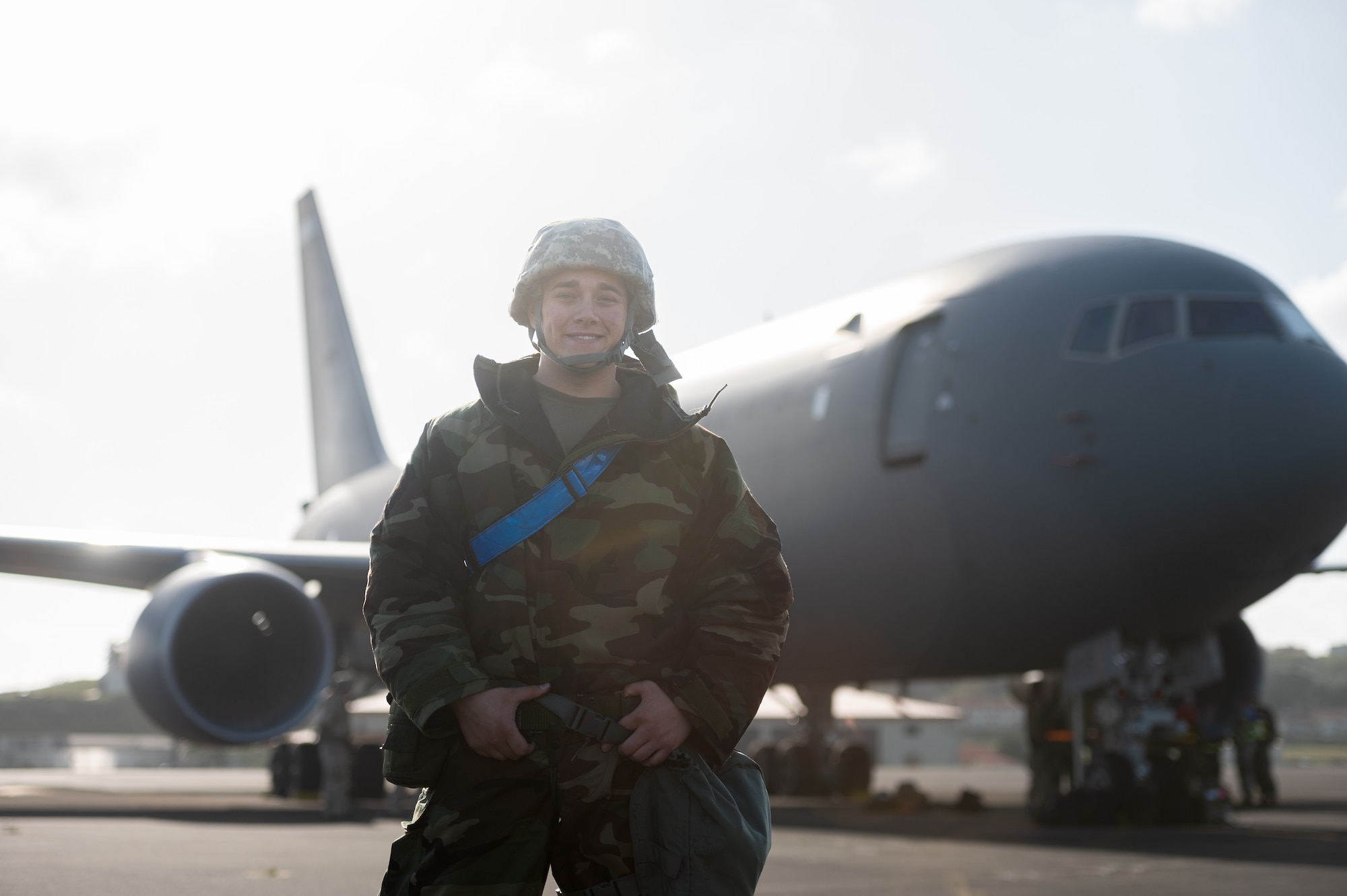 Airmen stands in chemical protective gear on the flight line