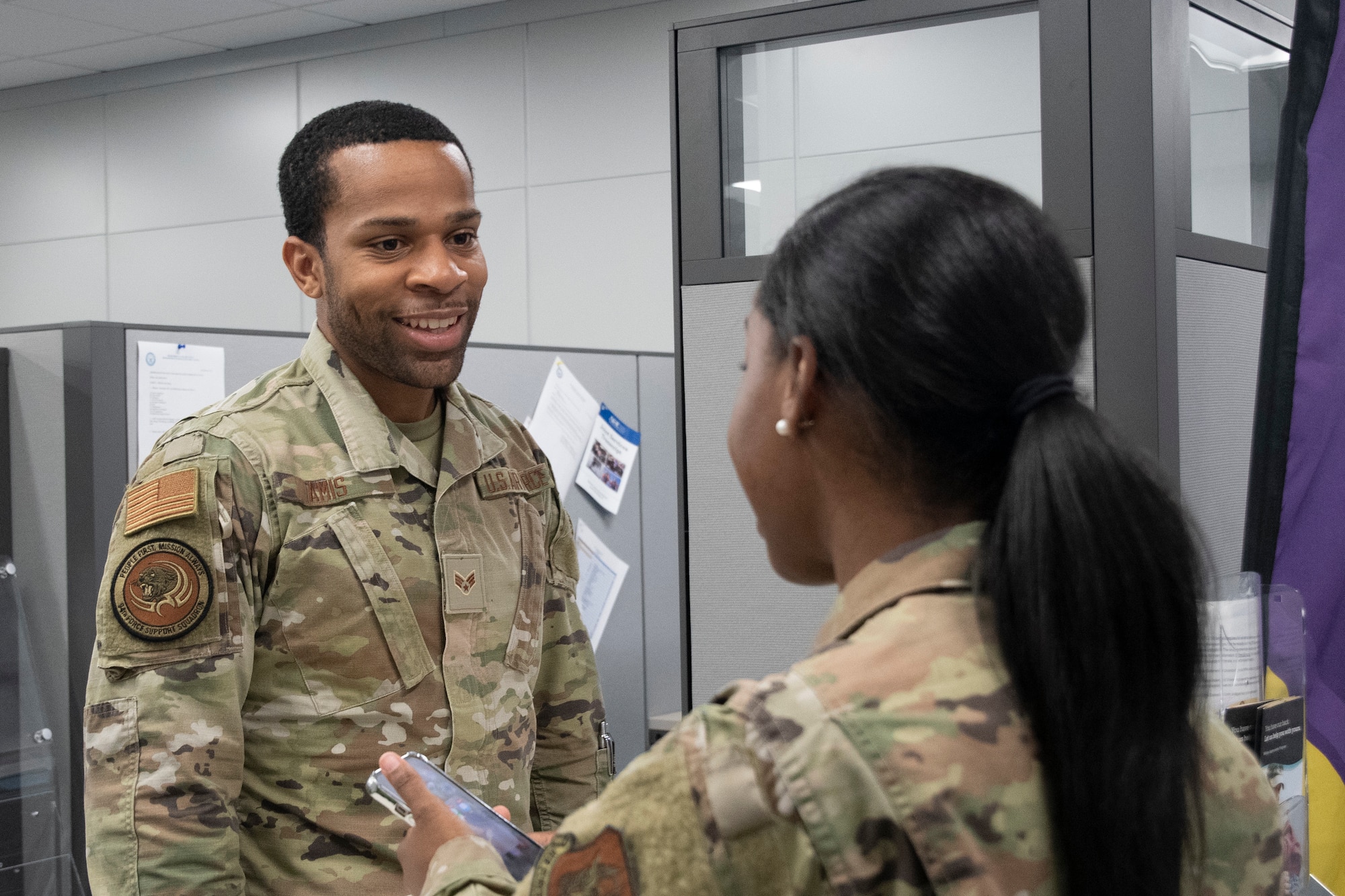 A man speaks to a woman at a counter.