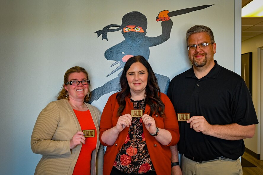 (from left to right) Sarah Chesser, construction flight chief, Nikole Braddy, services flight chief and Carlan Taft, plans and programs flight chief, assigned to the 5th Contracting Squadron, present their designation patches after receiving their Unlimited Warrant at Minot Air Force Base, North Dakota, May 15, 2023. The Unlimited Warrant allows the contracting officers to procure goods, services and construction assets with no limits on the dollar amount. (U.S. Air Force photo by Senior Airman Zachary Wright)