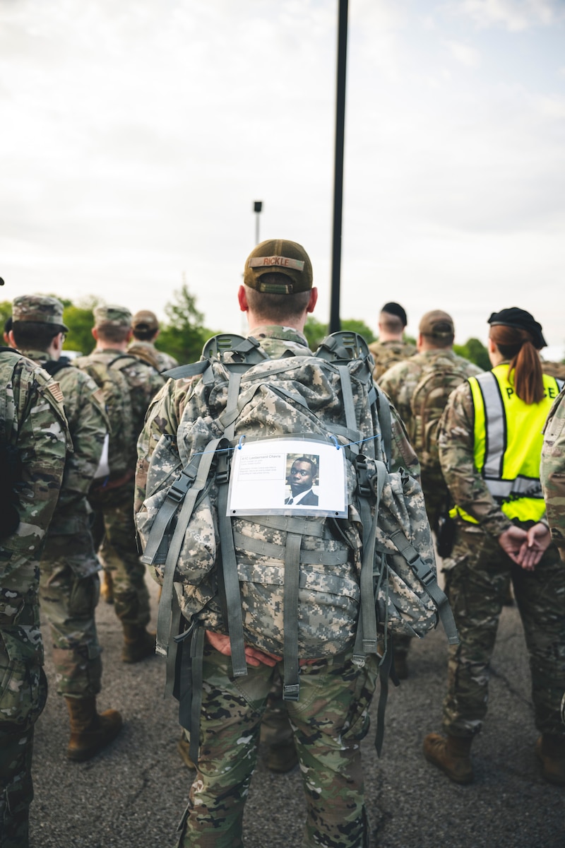 An Airman stands at parade rest with a picture of a fallen Airman attached to his rucksack  during the Ruck to Remember event commemorating National Police Week.
