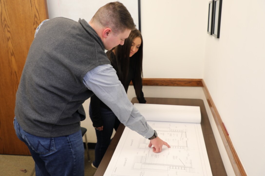 Luke Case, a professional engineer from the USACE Omaha District's F.E. Warren Resident Area Office team reviews a set of construction plans.