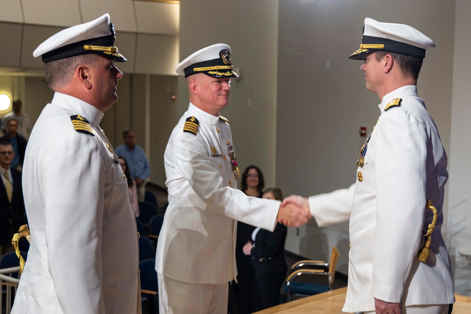 Naval Surface Warfare Center, Carderock Division’s outgoing Commanding Officer, Capt. Todd E. Hutchison (middle) shakes the hand of Rear Adm. Kevin Byrne (right), Commander, Naval Surface Warfare Center and Naval Undersea Warfare Center, while Carderock’s incoming Commanding Officer, Capt. Matthew Tardy (left) stands at attention during a change-of-command ceremony held in West Bethesda, Md., on May 12.  (U.S. Navy photo by Devin Pisner)