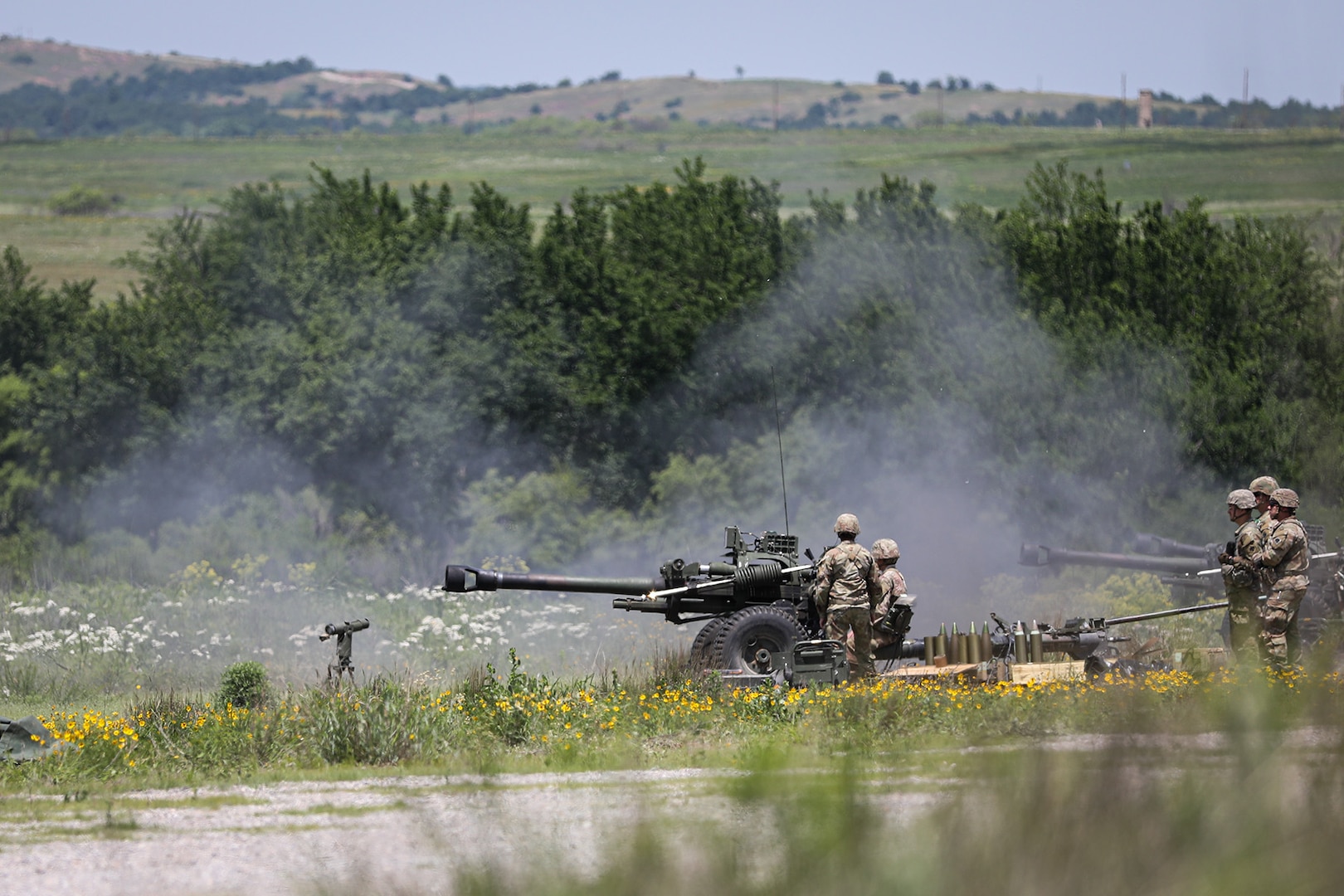 Soldiers assigned to Bravo Battery, 1st Battalion, 160th Field Artillery Regiment, 45th Infantry Brigade Combat Team prepare to load another round after firing an M119 howitzer during a live-fire demonstration on May 20, 2023 at Fort Sill, Oklahoma. The unit was performing the live-fire event as part of their second annual family day event that they have hosted in order to strengthen bonds between the Soldiers and their families. (Oklahoma National Guard photo by Pfc. Anthony Ackah-Mensah)