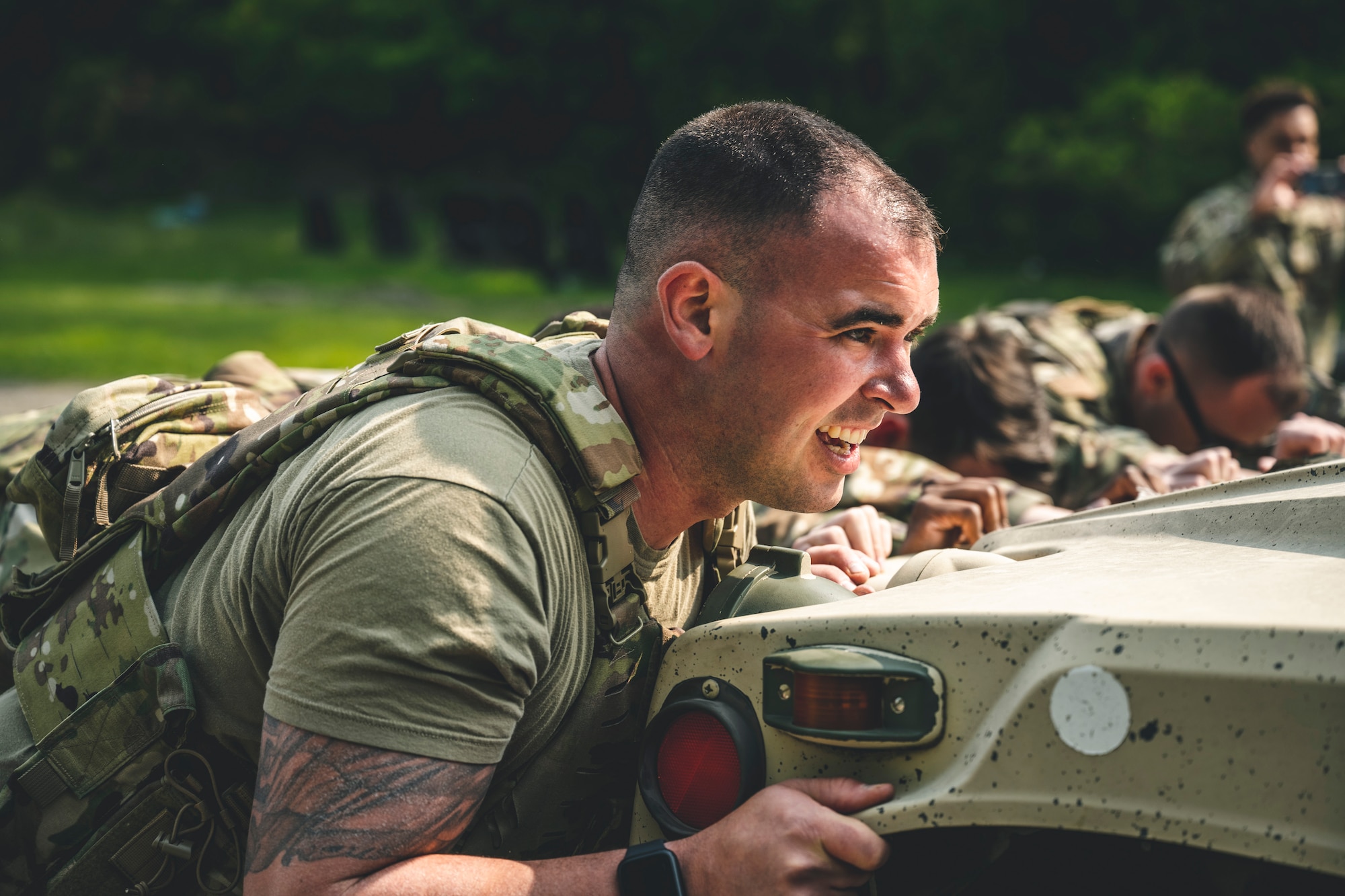 Airmen push a Humvee during the Defender Challenge