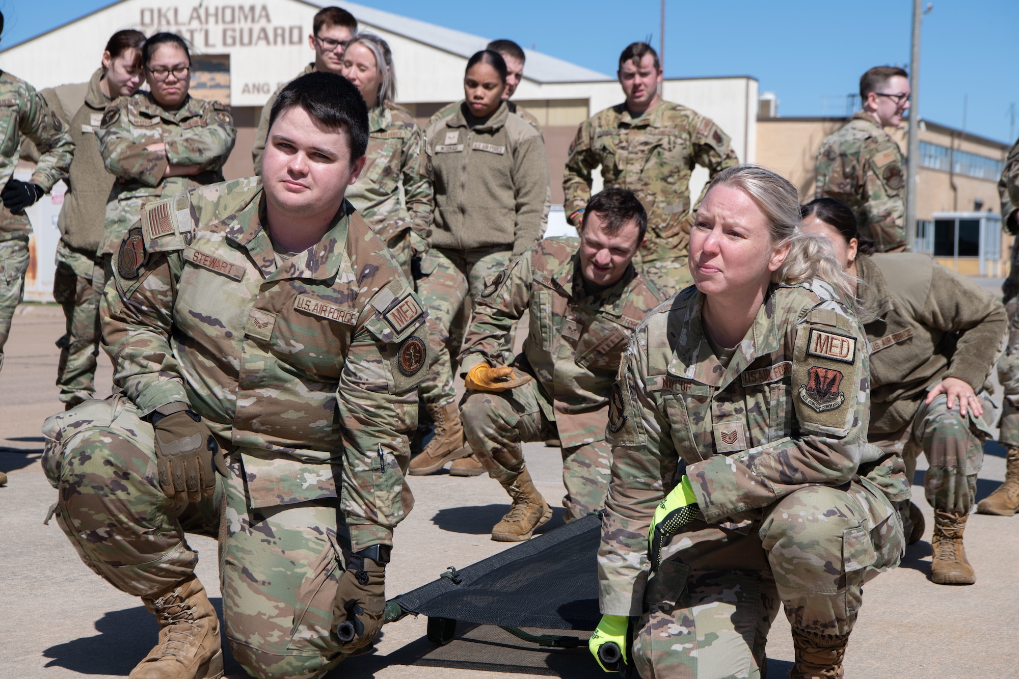 Four Airmen prepare to lift a litter