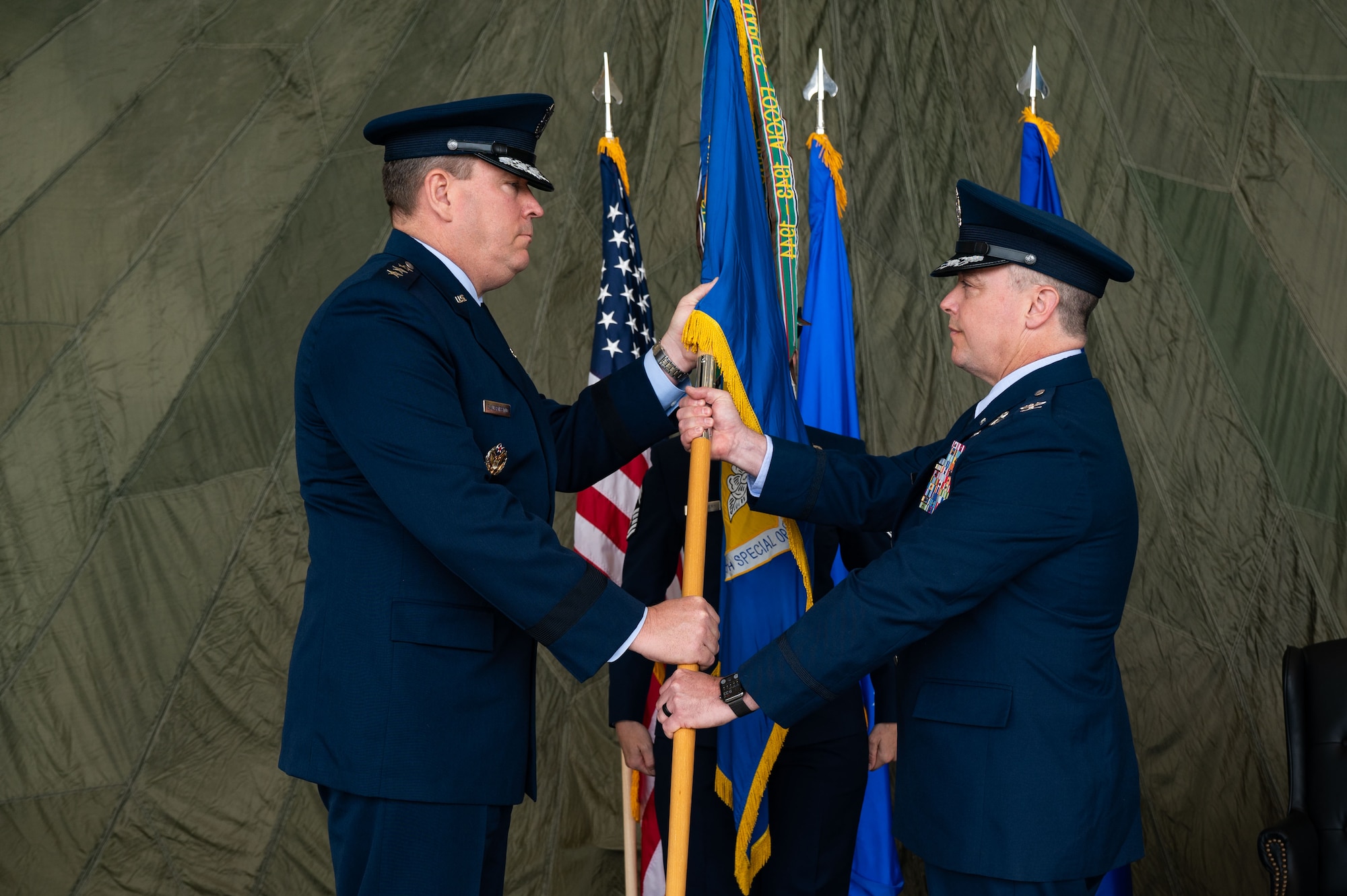 U.S. Air Force Lt. Gen. Tony Bauernfeind, Air Force Special Operations Command commander (left), facilitates the transfer of command to U.S. Air Force Col. Jeremy S. Bergin 27 Special Operations Wing commander, at Cannon Air Force Base, New Mexico, May 24, 2023.