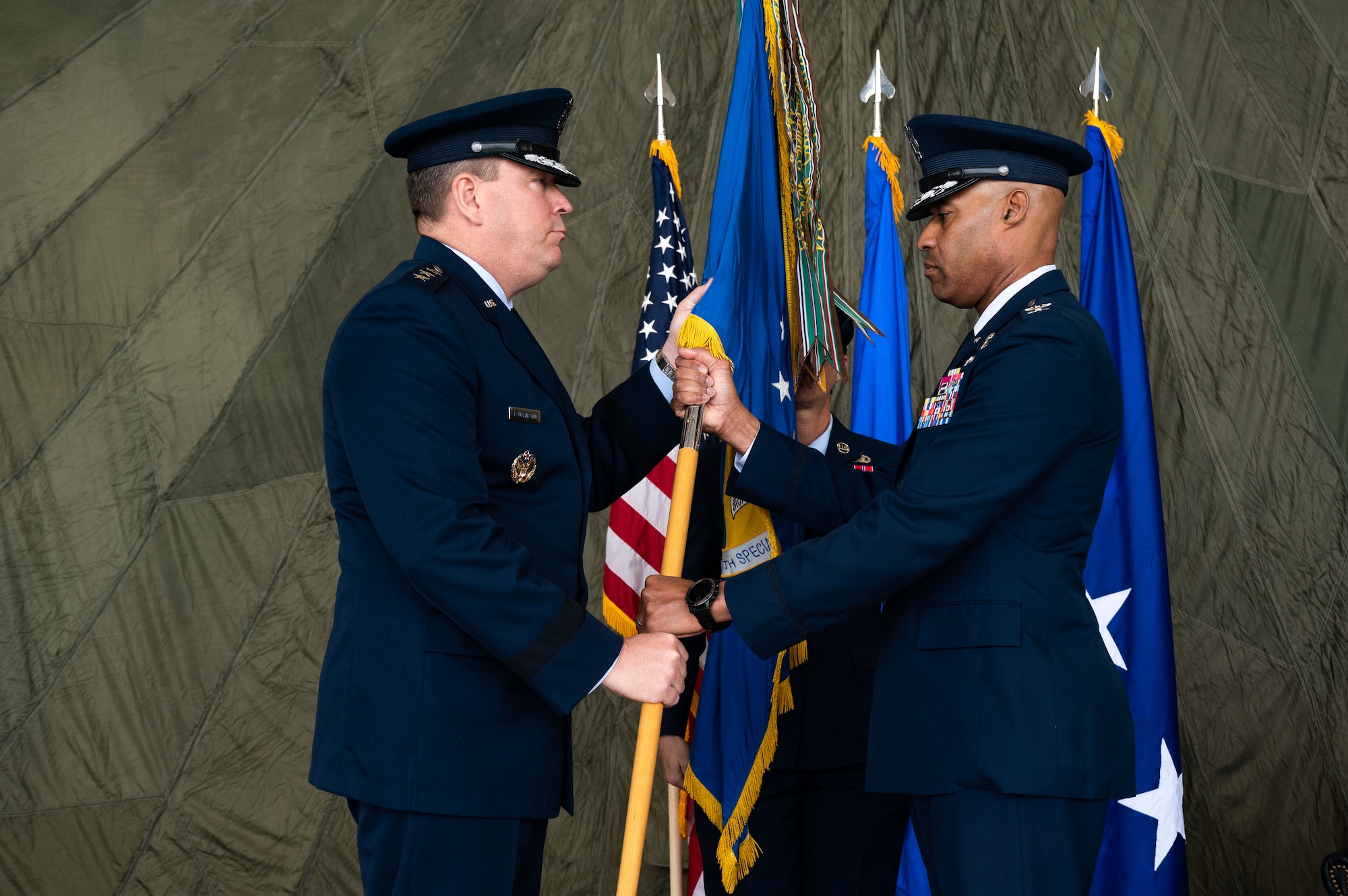 U.S. Air Force Lt. Gen. Tony Bauernfeind, Air Force Special Operations Command commander (left), receives the guidon from U.S. Air Force Col. Terence Taylor, 27th Special Operations Wing outgoing commander, at Cannon Air Force Base, New Mexico, May 24, 2023.
