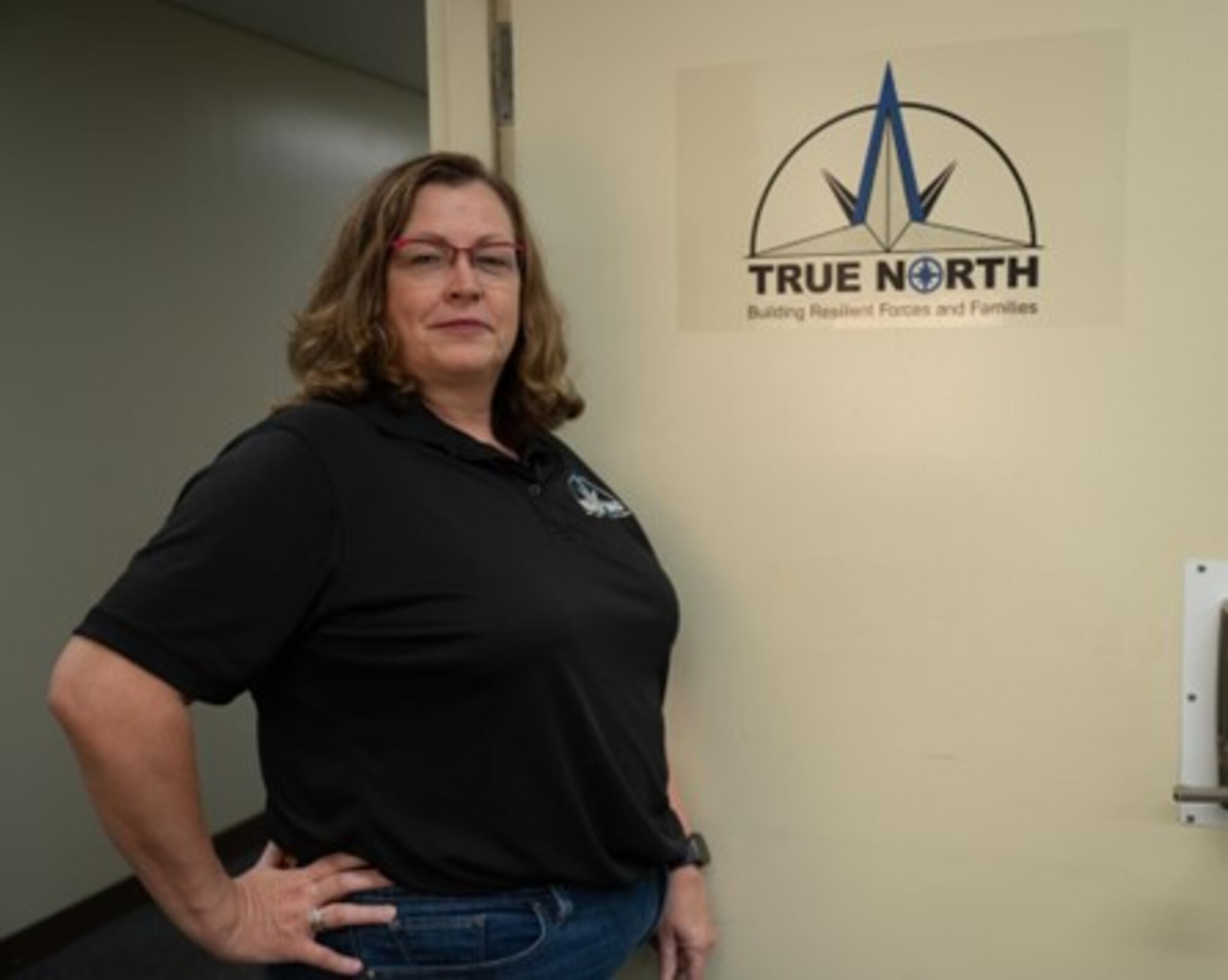 Rochelle Phelps, an embedded true north provider for the Wing Staff Agencies at Yokota Air Base, poses for a photo in front of a True North sign, May 19, 2023.