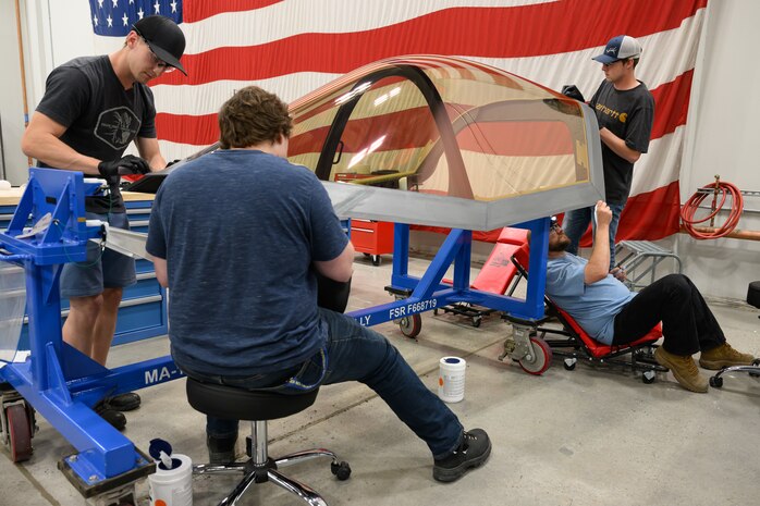 four men work on an F-35 canopy