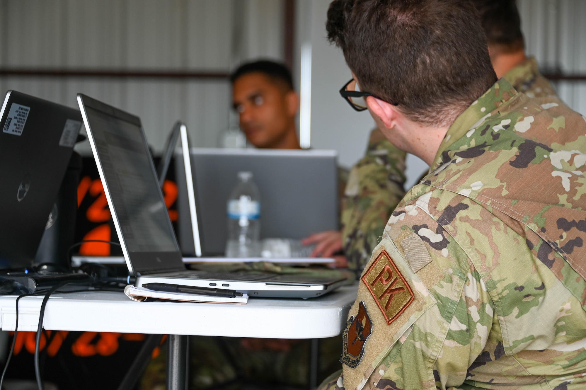 U.S. Air Force Airman 1st Class William Sasser, 97th Contracting Squadron (CONS) contract specialist, listens to Maj. Alejandro Sena, 97th CONS commander, during operation austere defender at Altus Air Force Base, Oklahoma, May 18, 2023. The exercise included talking through different situations unique to deployed environments. (U.S. Air Force photos by Senior Airman Kayla Christenson)