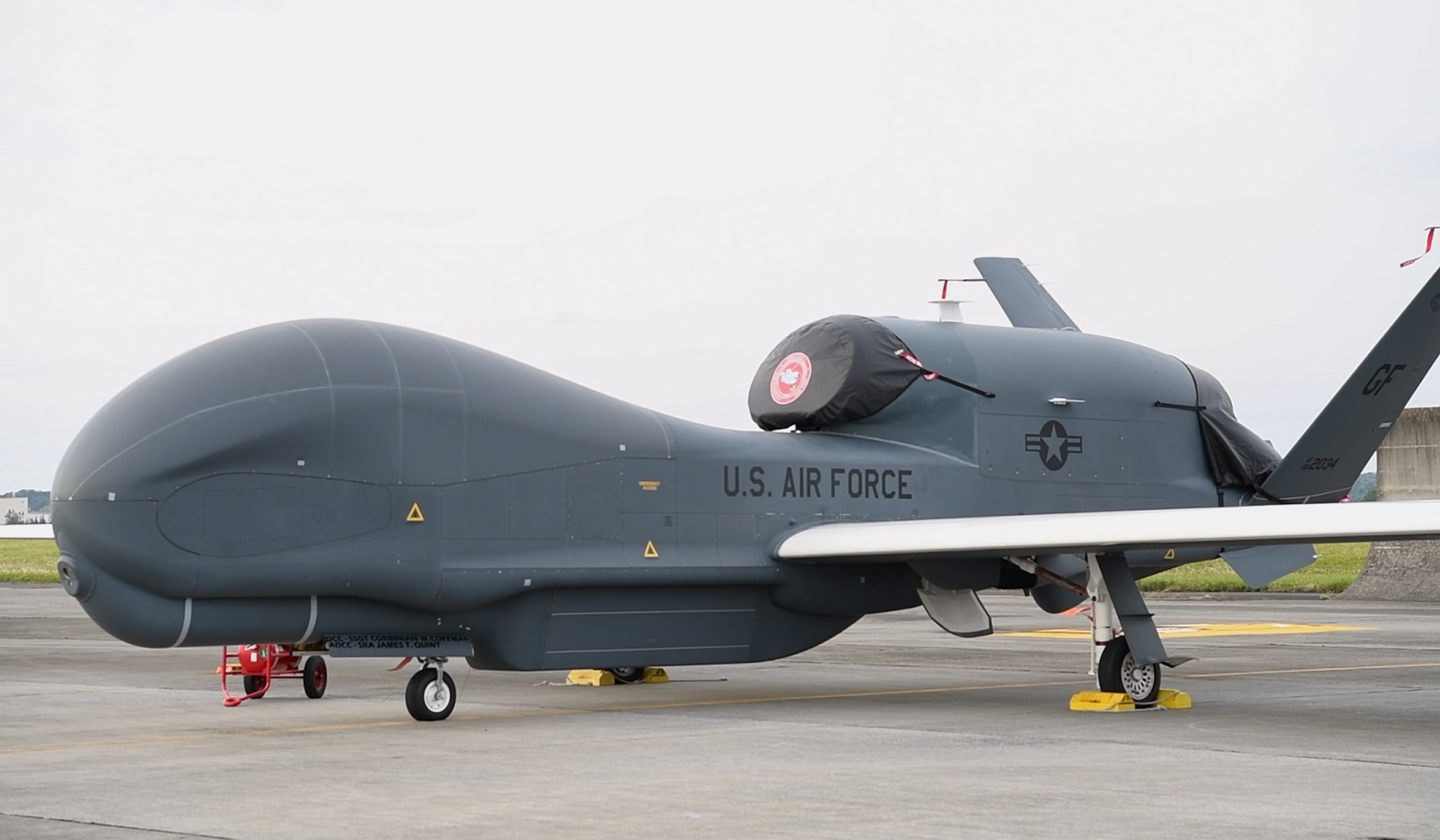 A large drone aircraft sits in a parking lot