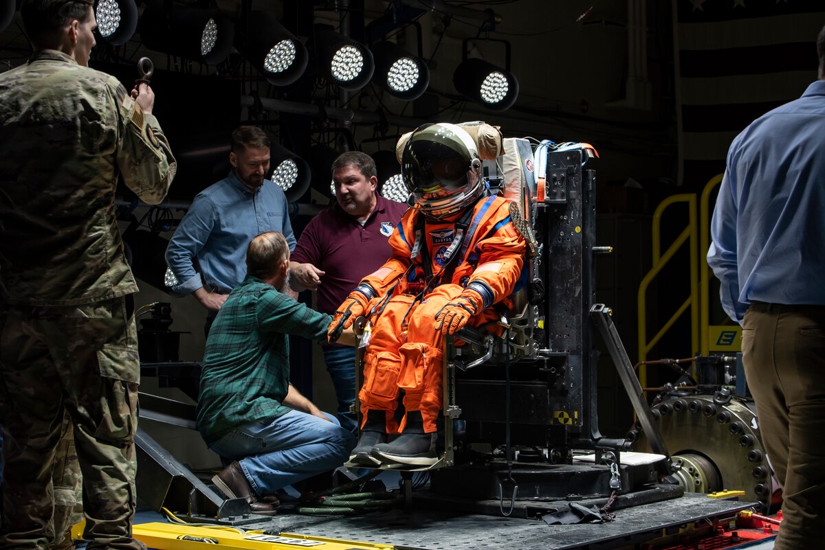 The Air Force Research Laboratory, or AFRL, and NASA staff adjust Campos, a fire and rescue training manikin, in the seat at the sled test facility at Wright-Patterson Air Force Base, Ohio, April 17, 2023. AFRL and NASA, along with other industry partners, such as Lockheed Martin, tested the most current iteration of an astronaut crew seat and flight suit that will be used on the Orion spacecraft during the next mission to the moon under the Artemis Program. The manikin used in the testing was Campos, named after the legendary Arturo Campos, an electrical engineer who was instrumental to saving the Apollo 13 crew. Campos is accurately weighed and has the appropriate density of a human for testing. (U.S. Air Force photo / Rick Eldridge)