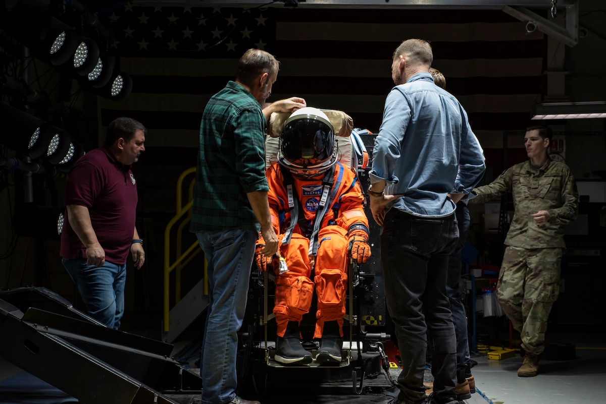 The Air Force Research Laboratory, or AFRL, and NASA staff adjust Campos, a fire and rescue training manikin, in the seat at the sled test facility at Wright-Patterson Air Force Base, Ohio, April 17, 2023. AFRL and NASA, along with other industry partners, such as Lockheed Martin, tested the most current iteration of an astronaut crew seat and flight suit that will be used on the Orion spacecraft during the next mission to the moon under the Artemis Program. The manikin used in the testing was Campos, named after the legendary Arturo Campos, an electrical engineer who was instrumental to saving the Apollo 13 crew. Campos is accurately weighed and has the appropriate density of a human for testing. (U.S. Air Force photo / Rick Eldridge)