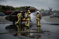 Firefighters put out a helicopter fire.