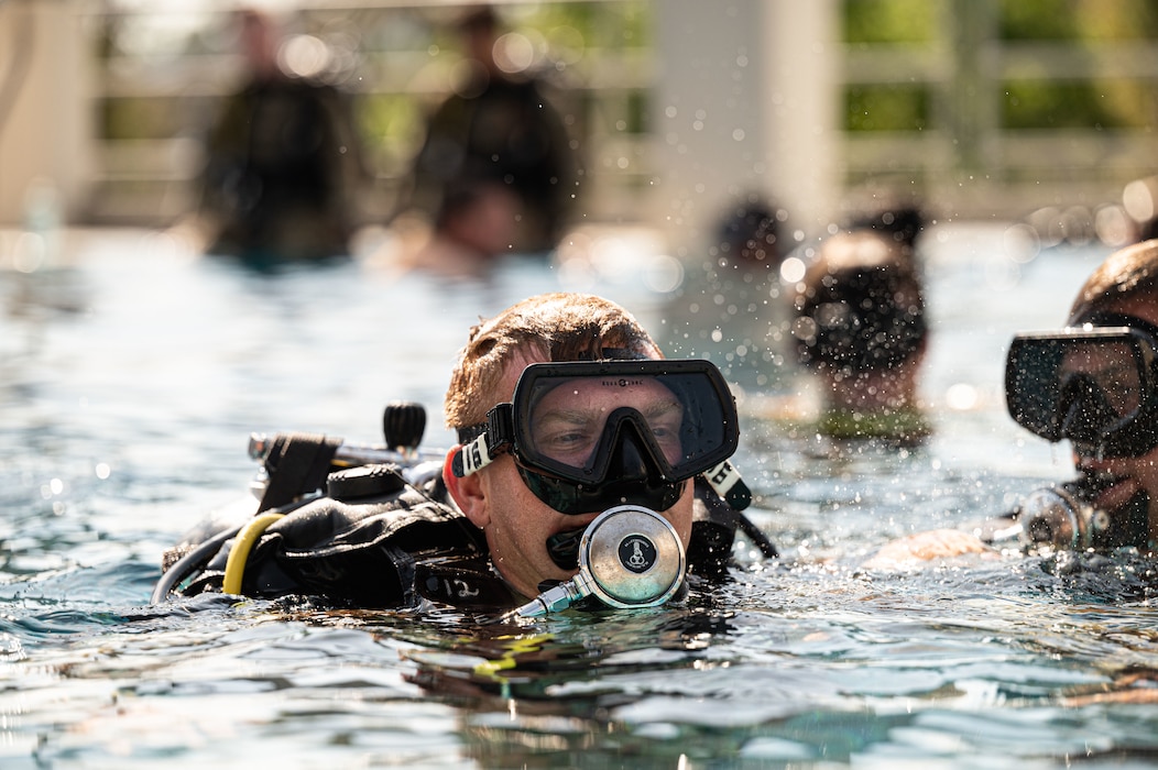 scuba diver sprays water as he surfaces