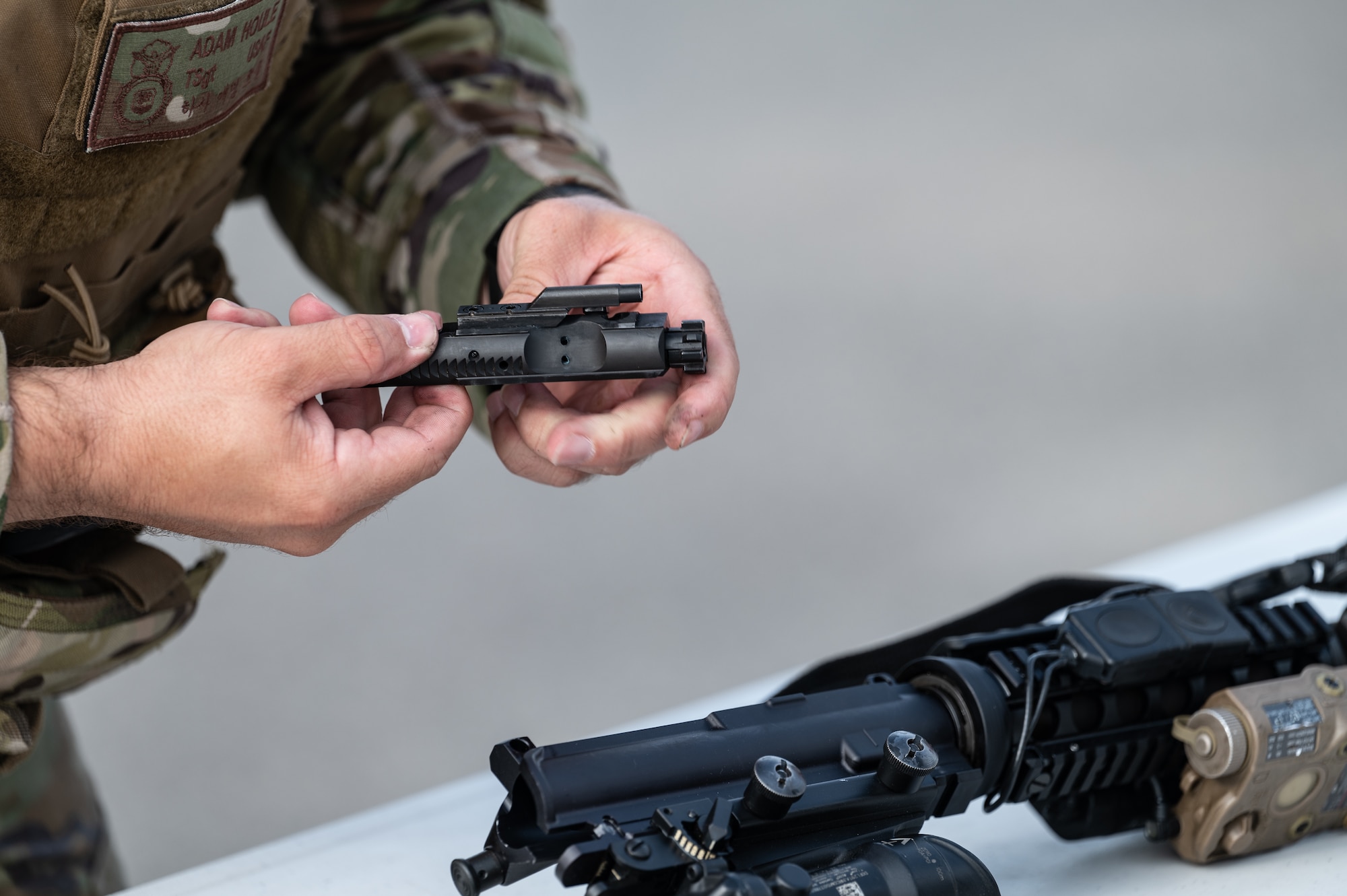 Tech. Sgt. Adam Houle, 8th Security Forces Squadron Alpha Flight chief, disassembles an M4 carbine rifle bolt carrier group during a Defenders’ challenge for the 2023 National Police Week at Kunsan Air Base, Republic of Korea, May 25, 2023. Each two-person team had to start and complete the various challenges together in order to move to the next challenge. (U.S. Air Force photo by Staff Sgt. Sadie Colbert)