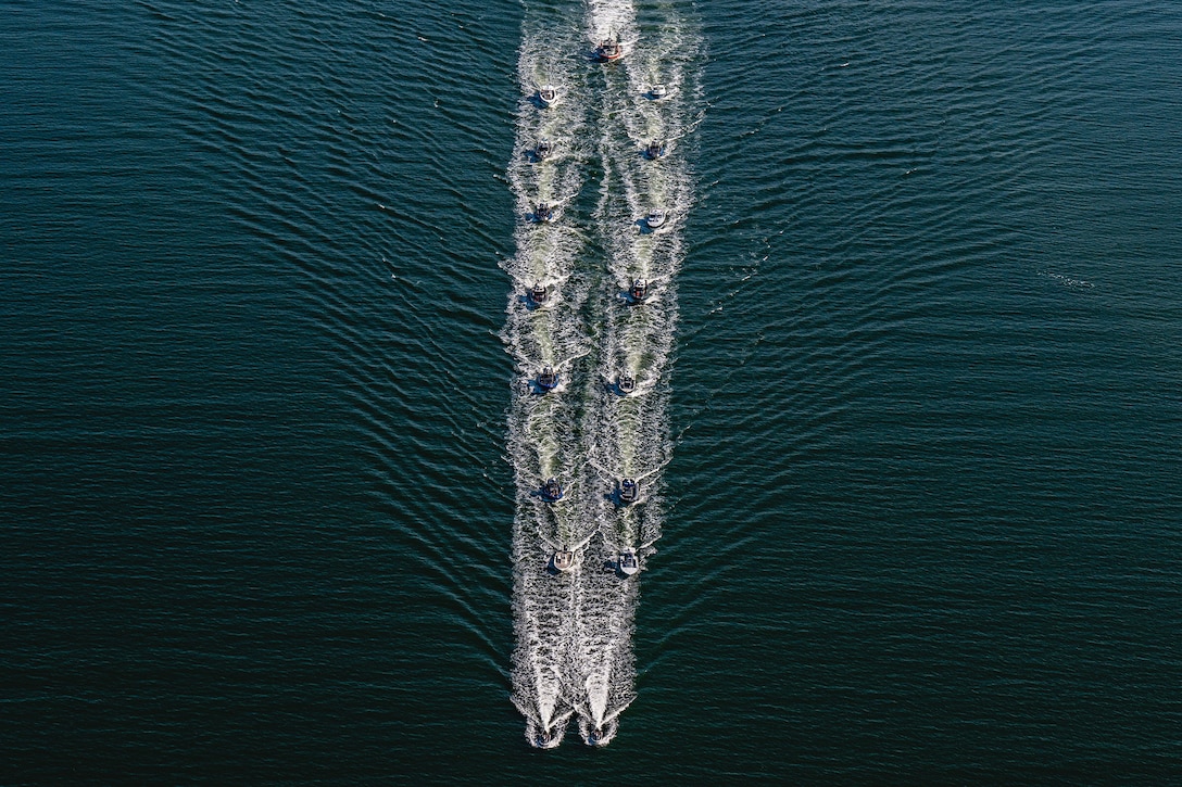 A group of boats sail in formation.