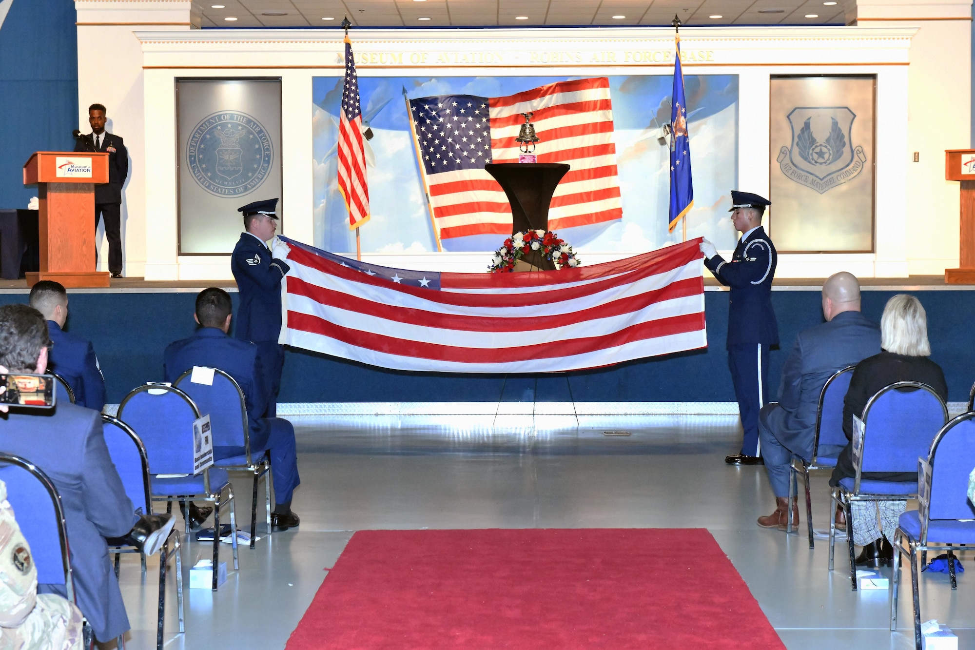 Two men in military uniform folding a United States flag