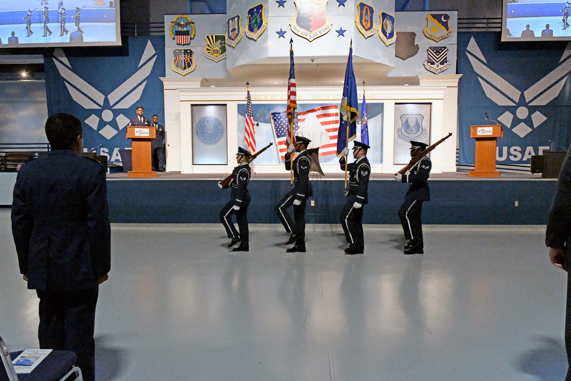 A group of four men in military uniform holding flags and rifles.