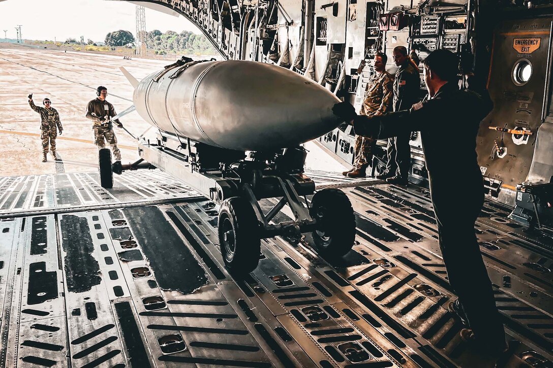 Airmen unload an extended range fuel tank from a plane.