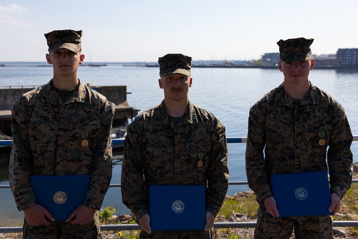 U.S. Marine Corps Lance Cpl. Aiden Morey, an unmanned aerial system operator, left, Lance Cpl. Colton Allen, a reconnaissance Marine, middle, and Lance Cpl. Christopher Butemeyer, a reconnaissance Marine, right, with Task Force 61/2.4 pose for a group photo after being awarded the Navy and Marine Corps Achievement medal in Tallinn, Estonia on May 15, 2023. The Marines were awarded for their fast thinking and direct involvement with saving an Estonian man’s life, while out on liberty.
