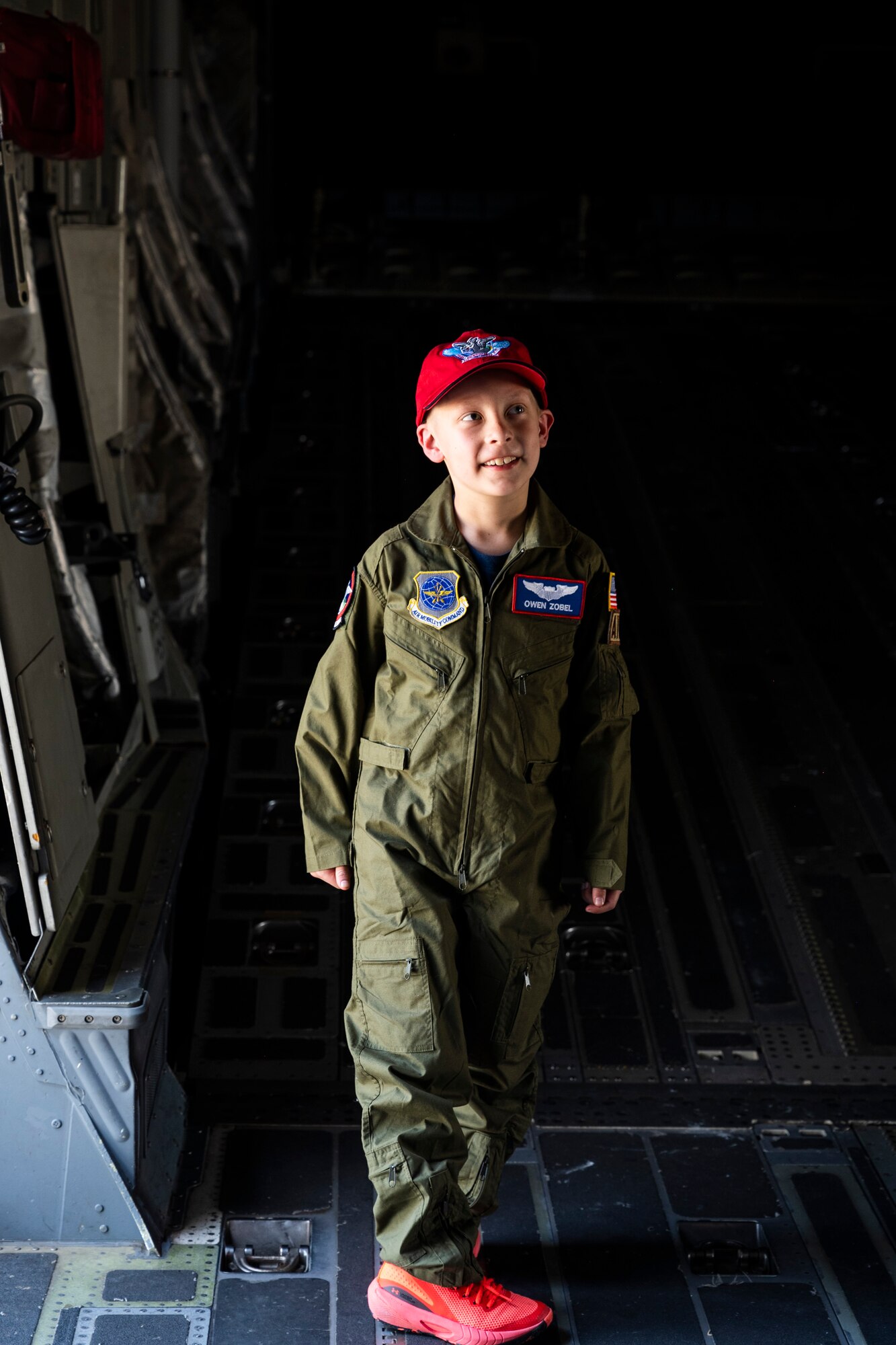 Owen Zobel, Team McChord’s newest pilot, tours a C-17 Globemaster III while taking part in the 4th Airlift Squadron’s Pilot for a Day program at Joint Base Lewis-McChord, Washington, May 11, 2023. The goal of the Pilot for a Day program is to provide children and their families in the local community who have catastrophic illnesses a once in a lifetime opportunity; the child is issued a flight suit and visits different mission sets around base such as the Security Forces Squadron Working Dog compound, the Fire Department, and a tour of the Air Traffic Control Tower and a C-17 Globemaster III. (U.S. Air Force photo by Staff Sgt. Rachel Williams)