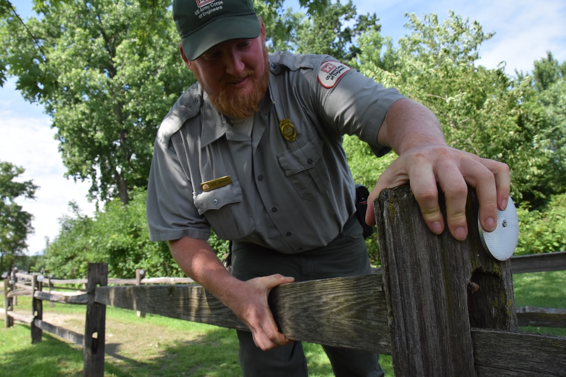 park ranger repairs a fence