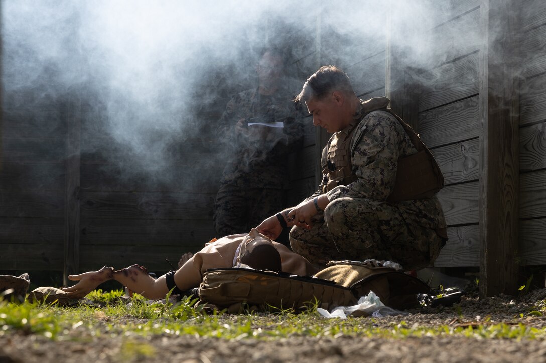 U.S. Navy Hospital Corpsman HM2 C Wallace, with II Marine Expeditionary Force (II MEF), provides triage to a simulated casualty during a Tactical Combat Casualty Care (TCCC) Tier Three Instructor test at Battle Skills Training on Camp Lejeune, North Carolina, May 18, 2023. Sailors with 2nd Marine Logistics Group hosted a TCCC Tier Three instructor course for Corpsmen from around II MEF to become instructors. (U.S. Marine Corps photo by Lance Cpl. Christian Salazar)