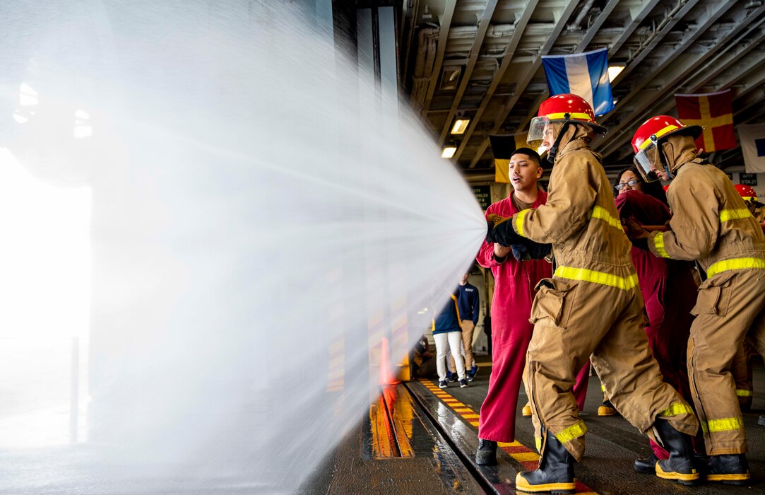 Sea Cadets and Junior ROTC members practice hose handling during damage control training aboard USS Wasp (LHD 1).