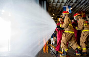 Sea Cadets and Junior ROTC members practice hose handling during damage control training aboard USS Wasp (LHD 1).