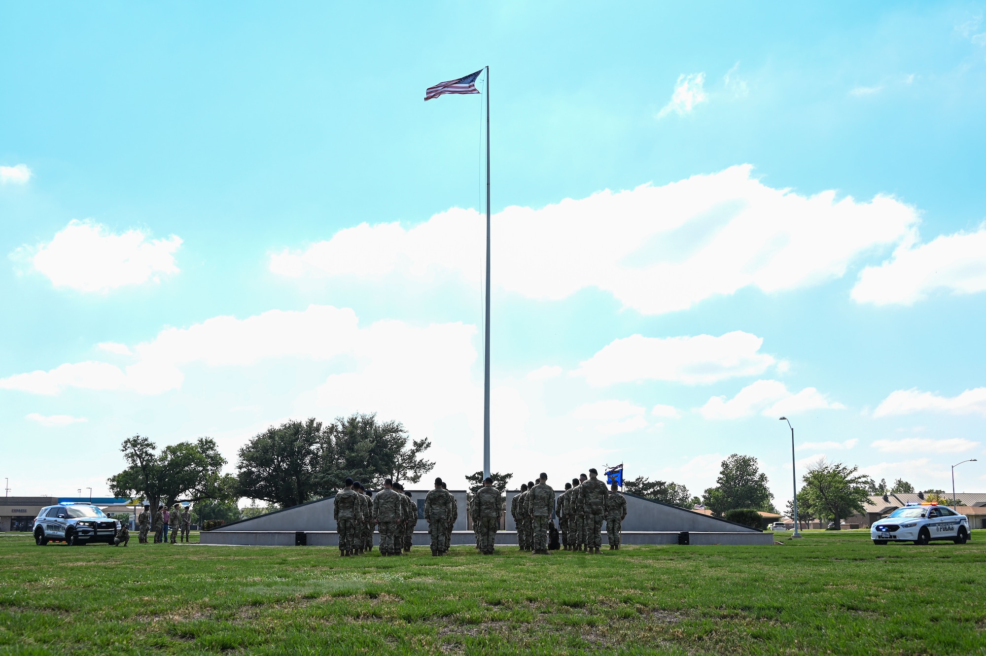 Airmen from the 97th Security Forces Squadron stand at attention in formation during the playing of the national anthem at Altus Air Force Base, Oklahoma, May 19, 2023. Police week concluded with a closing ceremony where defenders lowered the flag while the national anthem played. (U.S. Air Force photo by Senior Airman Kayla Christenson)