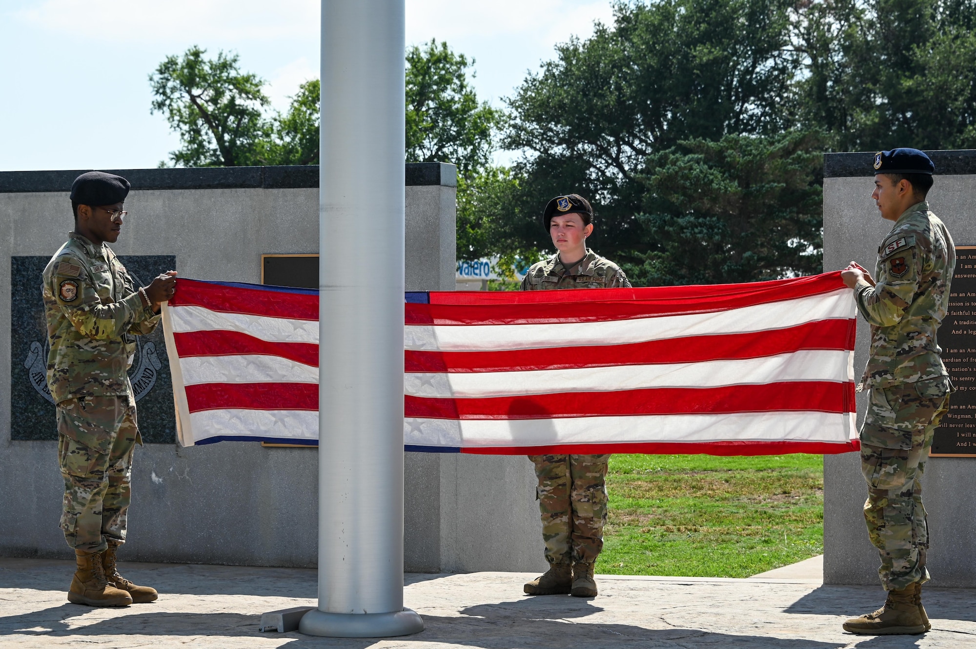 Airmen from the 97th Security Forces Squadron fold an American flag during a police week closing ceremony at Altus Air Force Base, Oklahoma, May 19, 2023. The flag was folded to show respect to the flag and to express gratitude to the individuals who fought and continue to fight for freedom at home and abroad. (U.S. Air Force photo by Senior Airman Kayla Christenson)