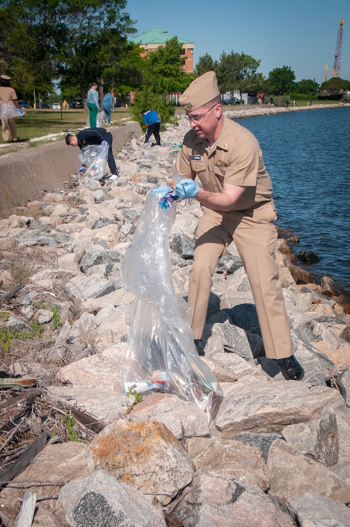 Capt. Brian Feldman, commanding officer of Navy Medicine Readiness and Training Command Portsmouth, picks up trash along the shoreline near Naval Medical Center Portsmouth during Clean the Base Day activities at the Naval Support Activity Hampton Roads Portsmouth Annex, May 5.