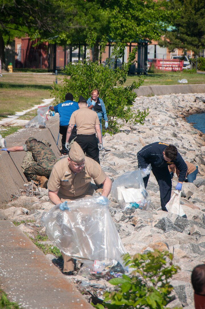 Capt. Brian Feldman, commanding officer of Navy Medicine Readiness and Training Command, and volunteers pick up trash along the shoreline near Naval Medical Center Portsmouth during Clean the Base Day activities at the Naval Support Activity Hampton Roads Portsmouth Annex May,5.