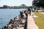 Teams of volunteers spread out to pick up trash along the shoreline near Naval Medical Center Portsmouth during Clean the Base Day activities at the Naval Support Activity Hampton Roads Portsmouth Annex May, 5