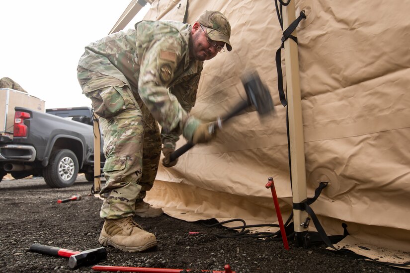 U.S. Air Force Tech. Sgt. Austin Myers, a water and fuel systems maintenance supervisor assigned to 773rd Civil Engineer Squadron, secures a solar panel system to a tent frame during an Agile Combat Employment air transportable clinic set up, during Northern Edge 23-1 at Joint Base Elmendorf-Richardson, Alaska, May 9, 2023.