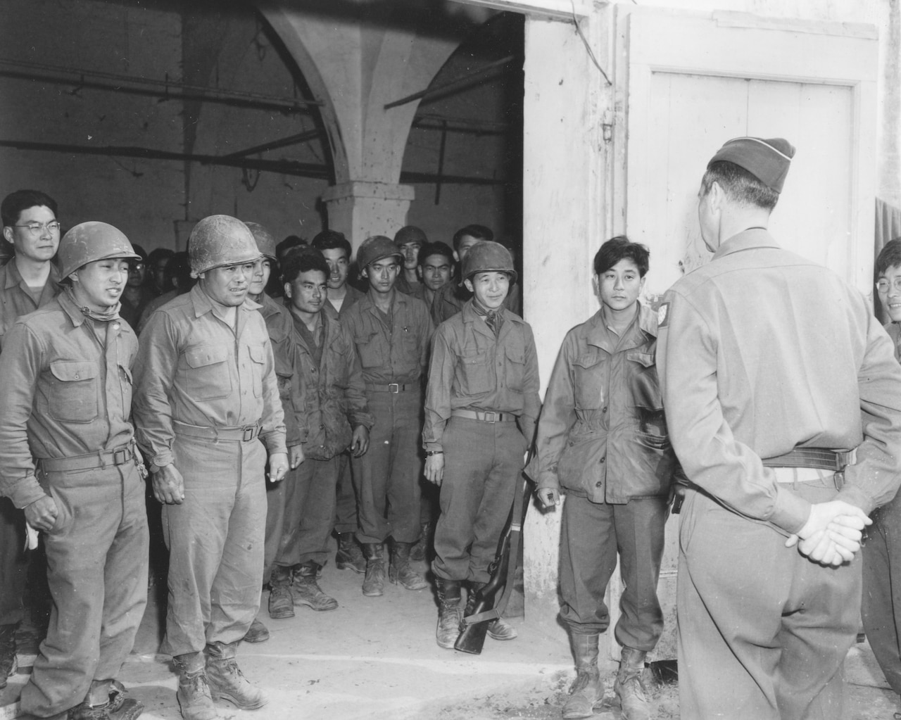 Several men stand at attention around another man.