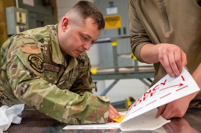 Tech. Sgt. Daniel Richards, a 934th Maintenance Squadron aircraft structural maintenance technician, applies a sticker for a sign onto sheet metal, at the Minneapolis-Saint Paul Air Reserve Station, Minnesota, May 6, 2023. ASM not only specializes in aircraft maintenance but with metal fabrication overall.(U.S. Air Force photo by Senior Airman Colten Tessness)